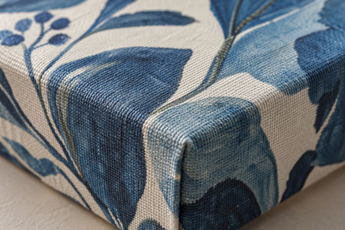 The corner of the wrap. The canvas folds round the edge and is stapled at the back, so the weave carries on round the side.